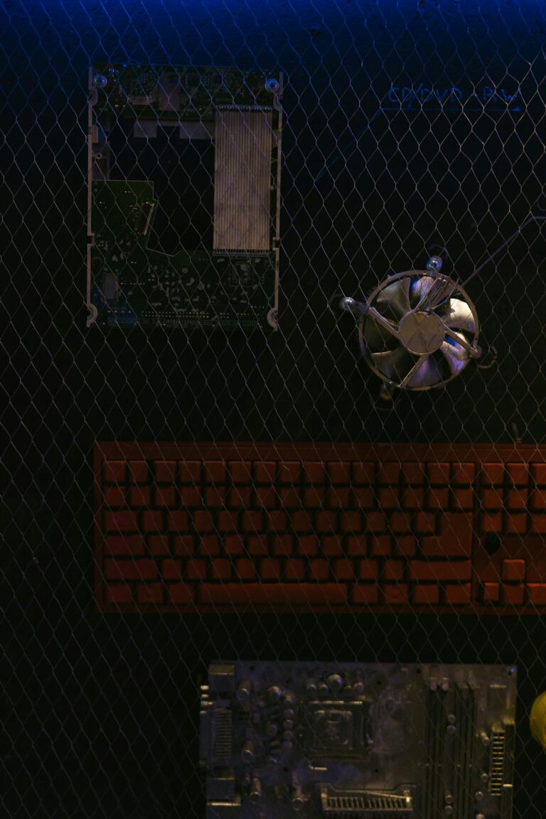 Overhead view of computer parts on a wire mesh with dramatic lighting.